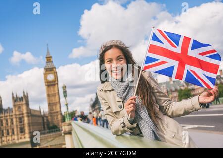 London Tourist Frau zeigt Flagge der Union Großbritannien britische UK Flagge. Asiatische Mädchen bei Big Ben auf Westminster Brücke auf Europa Feiertage halten Stockfoto