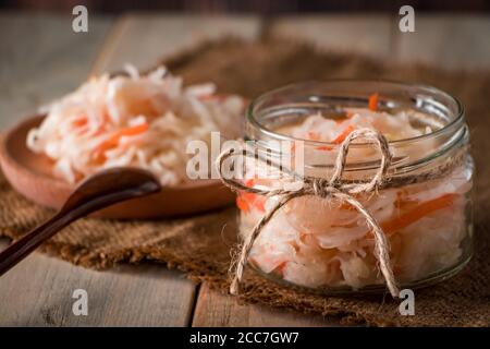 Hausgemachtes Sauerkraut auf Leinenhintergrund. Rustikaler Stil, Gemüsekonserven auf hellem Holzhintergrund. Öko-Lebensmittel, der Trend zu gesunder Ernährung. Stockfoto