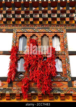 Red Chili Peppers hing to Dry outside a Window in Bhutan Stockfoto