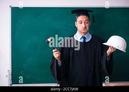 Junger männlicher Absolvent vor dem Vorstand Stockfoto