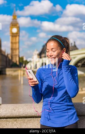 London Lifestyle Frau Läuferin Musik auf Smartphone in der Nähe von Big Ben hören. Weibliche Laufmädchen Ruhe nach dem Training in der Stadt. Fitness Mädchen lächelnd Stockfoto