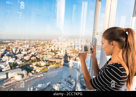 Touristenmädchen, das vom Shard aus ein Telefonfoto des Sonnenuntergangs der skyline von london gemacht hat. Reisetourismus in Europa Stockfoto