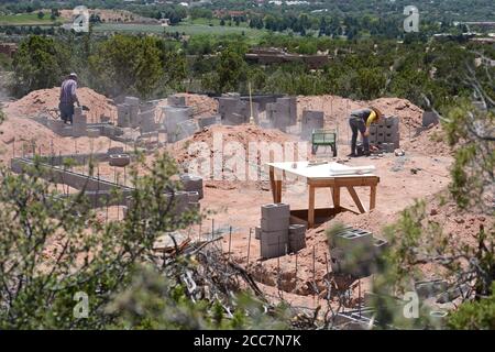 Bauarbeiter legen eine Blockgründung für ein neues Haus, das mit Blick auf Santa Fe, New Mexico, USA gebaut wird. Stockfoto