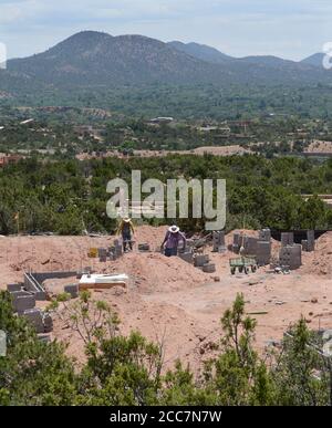Bauarbeiter legen eine Blockgründung für ein neues Haus, das mit Blick auf Santa Fe, New Mexico, USA gebaut wird. Stockfoto
