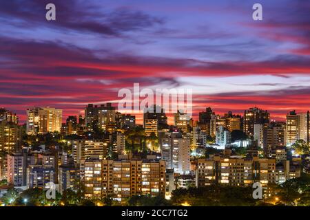 Porto Alegre, Brasilien Skyline mit dramatischen Himmel mit Wolken nach Sonnenuntergang. Hauptstadt des Bundesstaates Rio Grande do Sul. Wohngebäude. Farbenfroher Himmel. Stockfoto