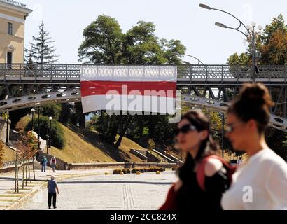 Kiew, Ukraine. August 2020. Zwei Frauen gehen an einer riesigen historischen belarussischen Flagge zur Unterstützung der Proteste in Belarus hängt an einer Brücke auf dem Unabhängigkeitsplatz in der Innenstadt von Kiew zu sehen.Proteste der Opposition in Belarus für die zweite Woche nach umstrittenen Präsidentschaftswahlen fortgesetzt. Kredit: SOPA Images Limited/Alamy Live Nachrichten Stockfoto