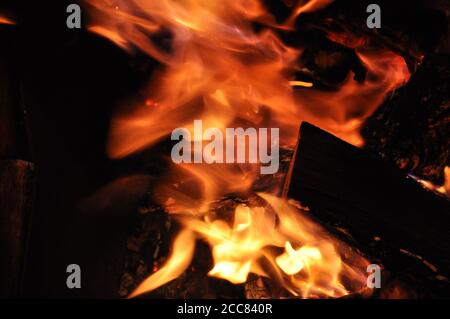 Verschwommenes Lagerfeuer lodert. Brennende Feuerstruktur. Abstrakte Flamme verschwommen Bewegung auf schwarzem Hintergrund Stockfoto