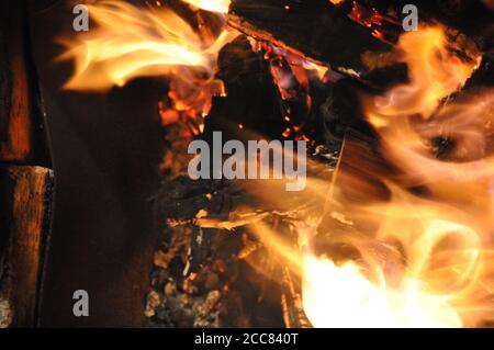 Defokussierter, texturierter Hintergrund mit Funkenspuren. Brennendes Feuerholz Lagerfeuer. Abstrakte Flamme verschwommen Bewegung Hintergrund Stockfoto