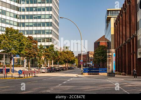 Hamburg / Deutschland - 09 06 2018: Stadtstraße und Bürgersteig in der Hamburger Geschäftsstadt nahe dem modernen Firmengebäude mit futuristischer geometrischer Form Stockfoto