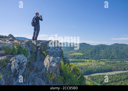 Der Mensch steht im Sommer auf dem Berg Stockfoto