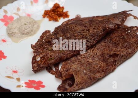 Ragi Dose oder Dosa, mit Fingerhirse, südindisches Frühstück, serviert mit Kokosnuss-Chutney Stockfoto