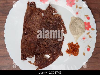 Ragi Dose oder Dosa, mit Fingerhirse, südindisches Frühstück, serviert mit Kokosnuss-Chutney Stockfoto