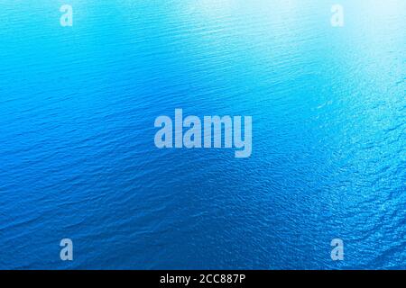 Luftaufnahme einer kristallklaren Meerwasser-Textur. Blick von oben natürlicher blauer Hintergrund. Reflektion des blauen Wassers. Blaue Meereswelle. Sommer Meer. Drohne. Stockfoto