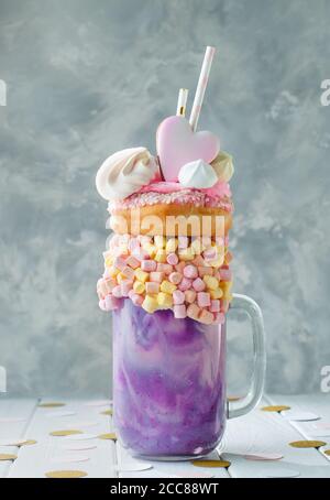 Freak Shake Topping mit Donut und Marshmallow auf grauem Hintergrund Stockfoto