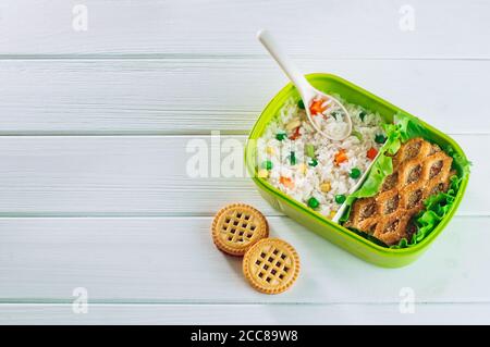 Lunchbox gefüllt mit Reis und Sandwich auf weißem Holz Hintergrund Stockfoto