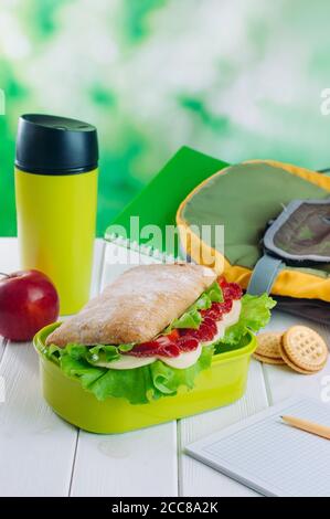 Lunchbox mit Sandwich in der Nähe Thermoskanne Becher und Stift auf Bürotisch Stockfoto