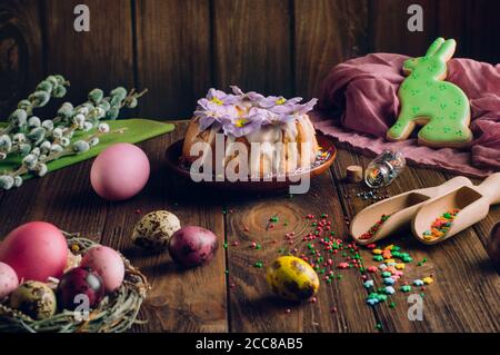 Die Hände des Mannes halten den Osterringkuchen über dem Holzhintergrund Stockfoto