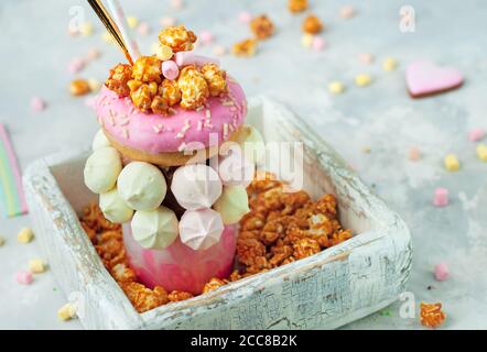 Raspberry Freak Shake Topping mit Donut in der weißen Holz Feld Stockfoto