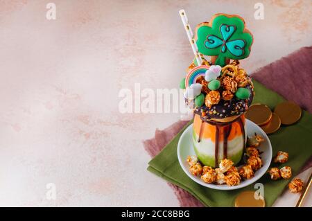 Dreifarbiger Freak Shake Topping mit Kleeblätzchen auf Beige Hintergrund Stockfoto