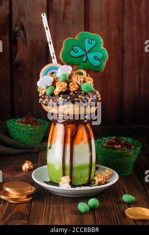 Dreifarbiger Freak Shake Topping mit Kleebokie auf Holz Hintergrund Stockfoto