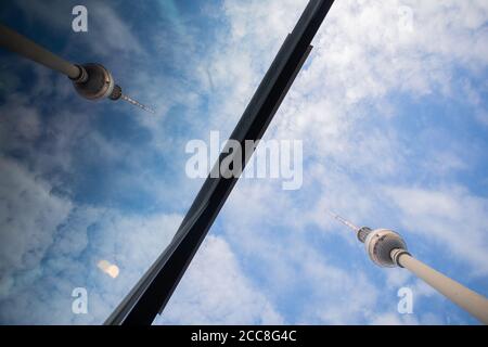 Berlin, Deutschland. August 2020. Der Berliner Fernsehturm spiegelt sich in einer Glasfront am Alexanderplatz, wenn der Himmel leicht bewölkt ist. Quelle: Christoph Soeder/dpa/Alamy Live News Stockfoto