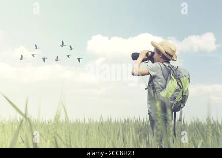 Junger Vogelbeobachter schaut mit seinem Fernglas die Vogelwelt an Stockfoto