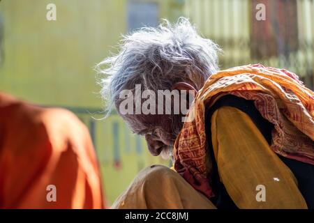 Orchha, Madhya Pradesh, Indien - März 2019: Nahaufnahme eines älteren indischen männlichen Hindu-Pilgers in ethnischen Kleidern, der vor einem alten t sitzt Stockfoto