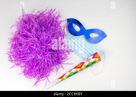 Blaue Schutzmaske mit Maske und Papiertrompete und Perücke, Partyzubehör Stockfoto