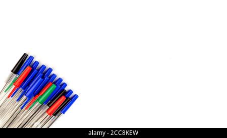 Stapel von vielen mehrfarbigen Kunststoff Kugelschreiber isoliert auf weißem Hintergrund. Abstrakt Schreibwaren Hintergrund. 16x9-Format. Draufsicht. Nahaufnahme. Viele Stockfoto