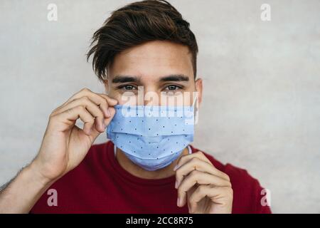Junger Mann trägt Gesichtsmaske Porträt - Latein Junge mit Schutzmaske zur Verhinderung der Ausbreitung von Corona-Virus Stockfoto