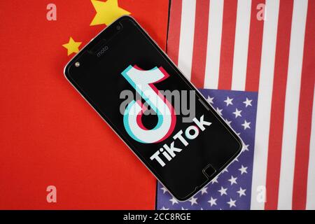 Maski, Indien 04, August 2020 - TikTok App-Logo auf dem Smartphone-Bildschirm und platziert auf China und USA Flaggen - die App ist in der Mitte der USA - China Stockfoto