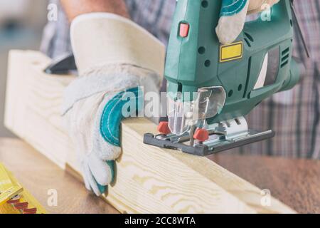 Man schneidet ein Stück Holz mit einer Stichsäge Stockfoto