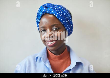 Porträt einer afrikanischen jungen Frau mit schönem Schal auf ihr Kopf lächelt an der Kamera Stockfoto