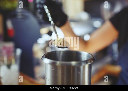 Barkeeper trägt medizinische Latex schwarze Handschuhe, Mojito Cocktail.Process der Bartender in Bar, Gießen einen Esslöffel braunen Zucker in Shaker Stockfoto