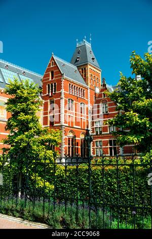 Schöne Aussicht auf die Fassade des alten Gebäudes unter Bäumen. Von Amsterdam - Juni 2019 Niederlande. Stockfoto