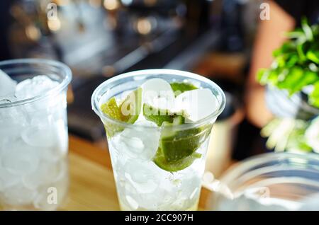 Barkeeper macht Mojito-Cocktail. Prozess der Barkeeper in Bar.Minze Blätter, Eis, Limette - Zutaten für Getränke in Nachtclub Stockfoto