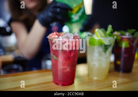 Barkeeper trägt medizinische Latex schwarze Handschuhe, Mojito Cocktail.Process der Bartend in bar.verschwommenes Bild, selektiver Fokus Stockfoto