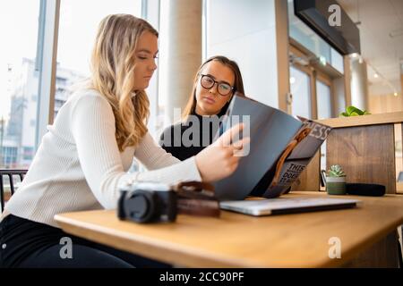 Ernsthafte Junge Blogger Diskutieren Über Veröffentlichung In Cafe Stockfoto