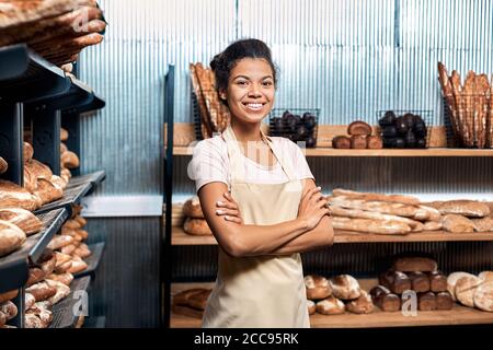 Junge Erwachsene Frau, die in der Bäckerei der Familie steht Stockfoto