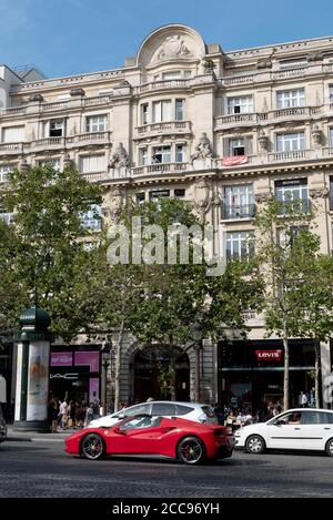 Paris (Frankreich): Gebäudefassaden und roter Ferrari entlang der Champs Elysees Avenue, im 8. Arrondissement (Bezirk) Stockfoto