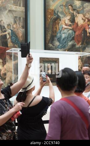 Die Mona Lisa, von Leonardo da Vinci, im Louvre Museum in Paris Touristen fotografieren das Gemälde mit Smartphones Stockfoto