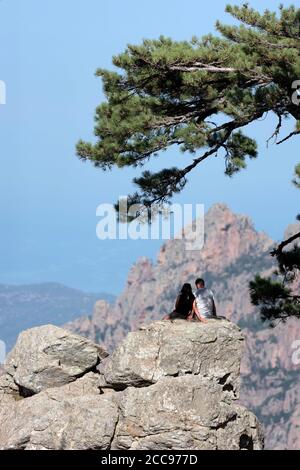 Südkorsika: Paar sitzt und umarmt vor der herrlichen felsigen Landschaft der Bavella Berge. Stockfoto
