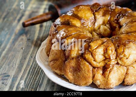 Dessert von Pull Apart Carrot Cake Monkey Bread. Ein Hefegebundener Kuchen aus Zimt, Karotten, Nüssen und einer braunen Zuckerglasur. Selektiver Fokus mit blu Stockfoto