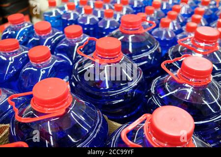 Dunkelblaue Flüssigkeit in den Plastikflaschen mit roten Verschlüssen. Stockfoto