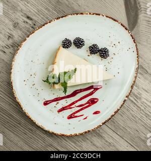 Käsekuchen mit Brombeere auf schönem Teller. Stockfoto