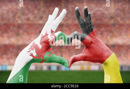 Die Hände der Person bilden ein Herz mit den Flaggen von Wales Und Deutschland - Liebe zum Fußball-Konzept Stockfoto