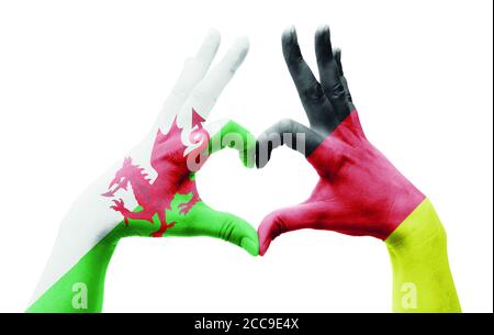 Die Hände der Person bilden ein Herz mit den Flaggen von Wales Und Deutschland - Liebe zum Fußball-Konzept Stockfoto