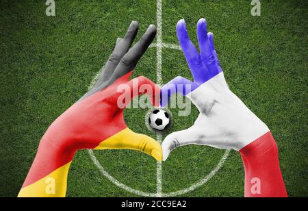 Die Hände eines Menschen bilden ein Herz mit den Flaggen Deutschlands Und Frankreich - Liebe zum Fußball-Konzept Stockfoto