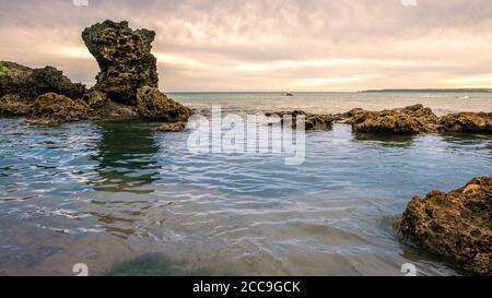 Traumhaft schöner Sonnenuntergang an der Südküste Taiwans. Ein Strand mit Steinen und goldenem Sonnenuntergang von Kenting. Wunderschöne Ozeanlandschaft in Pingtu Stockfoto