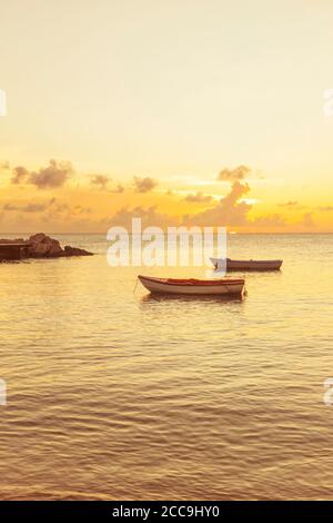 Zwei kleine Holzboote in goldenem Sonnenuntergang in der Karibik Meer Stockfoto
